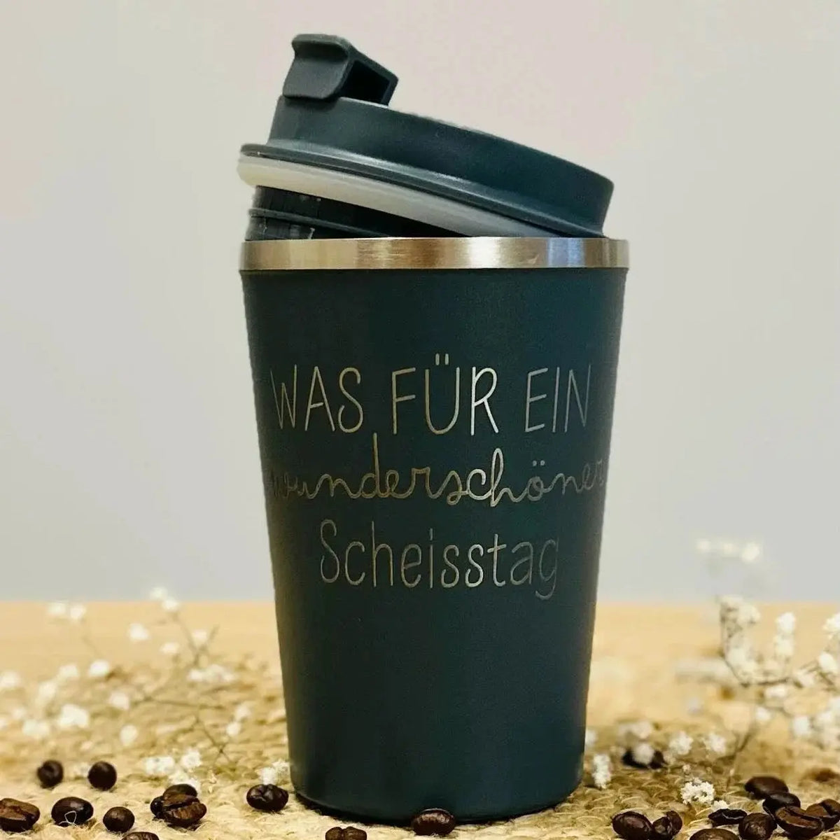 Personalisierter schwarzer Thermobecher mit Gravur „Was für ein wunderschöner Scheisstag“, Kaffeebohnen und Trockenblumen, Lieblingsschuppen.de Geschenkidee.
