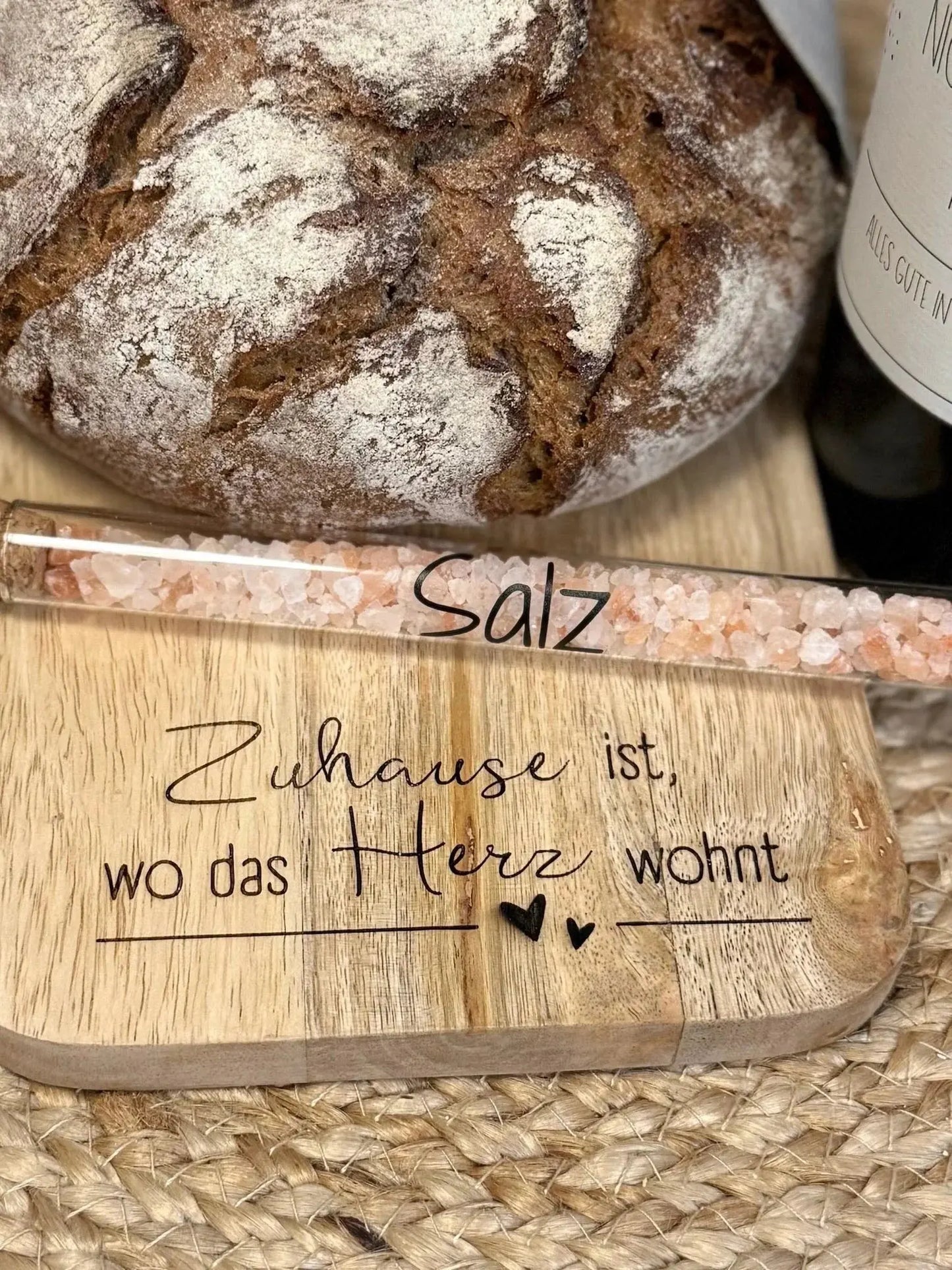 Rustikales Brot, pinkes Salz im Reagenzglas und graviertes Holzbrett mit Spruch, Geschenkidee