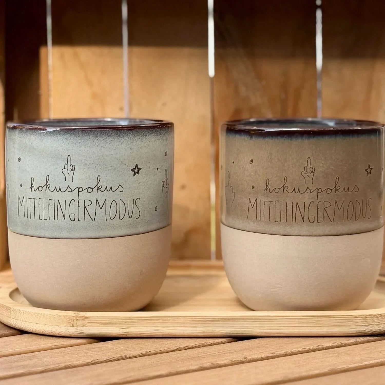 Zwei personalisierte Keramiktassen mit Gravur 'hokuspokus MITTELFINGERMODUS' auf Holztablett, Lieblingsschuppen.de Geschenkidee.
